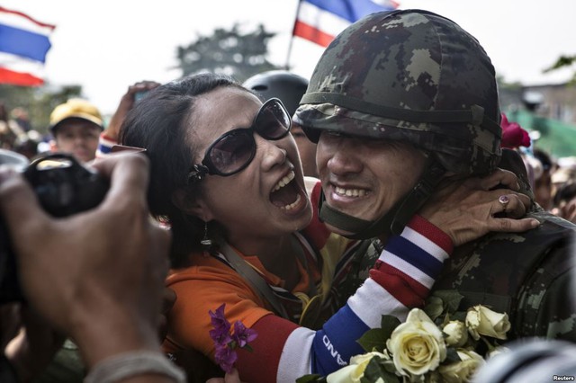 Một người biểu tình chống phủ ôm một binh sĩ sau khi một số cảnh sát tự nguyện rời vị trí trước tòa nhà chính phủ ở Bangkok, Thái Lan.