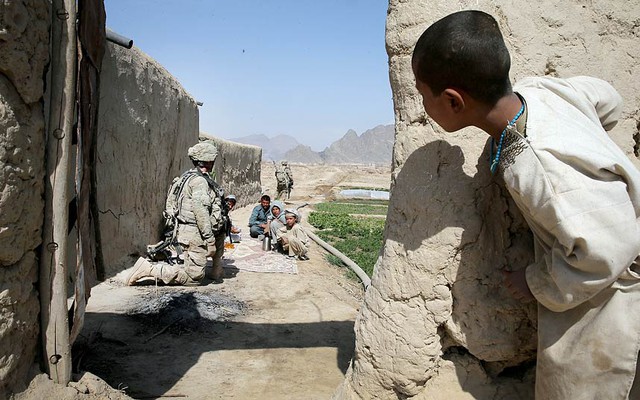 Một cậu bé nhìn các binh sĩ Mỹ dừng tại một ngôi làng khi tuần tra qua vùng Kandahar, Afghanistan.