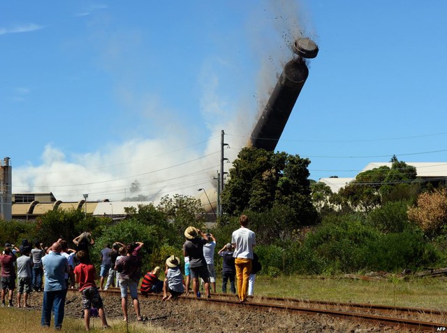 Mọi người đứng xem cột khói cao 200m được đánh đổ bằng thuốc nổ tại Port Kembla, Sydney, Australia.