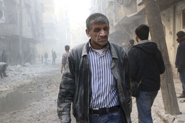 Một người đàn ông chạy khỏi hiện trường vụ nổ bom được thả bởi quân đội chính phủ ở Aleppo, Syria.