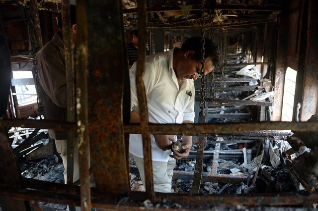 Các nhân viên điều tra kiểm tra hiện trường một tòa tàu bị bốc cháy ở Mumbai, Ấn Độ.