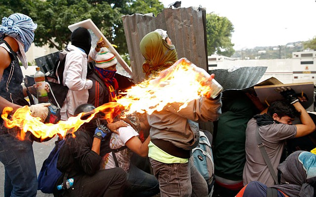 Những người biểu tình chống chính phủ ném bom xăng vào cảnh sát tại Caracas, Venezuela.
