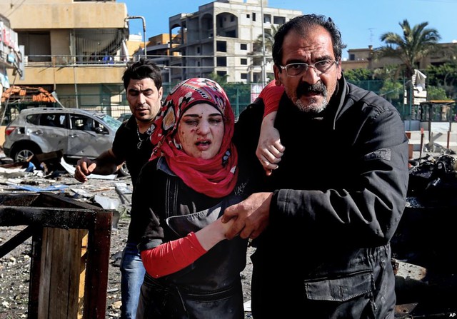 Một người đàn ông giúp đỡ nạn nhân bị thương trong vụ đánh bom gần đại sứ quán Kuwait ở Beirut, Li Băng.