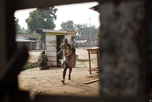 Một phụ nữ chạy tìm nơi trú ẩn khi các cuộc đấu súng ác liệt xảy ra giữa binh sĩ Pháp và các phiến quân Hồi giáo địa phương ở Bangui, Trung Phi.