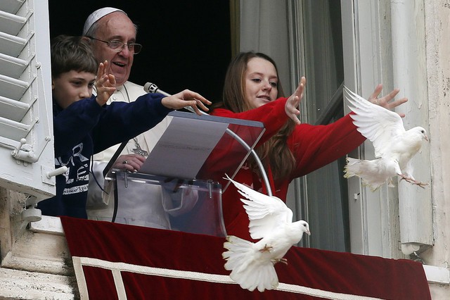 Giáo hoàng Francis nhìn trẻ em thả chim bồ câu trong một lễ cầu nguyện tại quảng trường St. Peter ở Vatican.