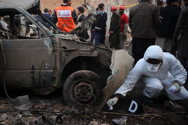 Nhân viên an ninh kiểm tra hiện trường vụ đánh bom xe ô tô tại một cửa hàng sữa chữa ô tô Peshawar, Pakistan,  khiến 6 người thiệt mạng.