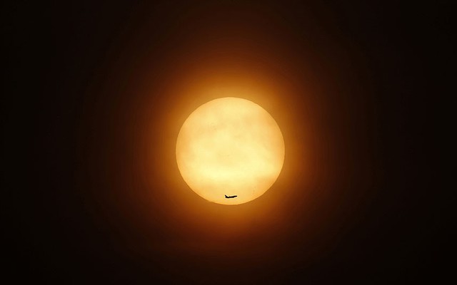 Một chiếc phi cơ nay qua Mặt trời đang lặn ở Thượng Hải, Trung Quốc.