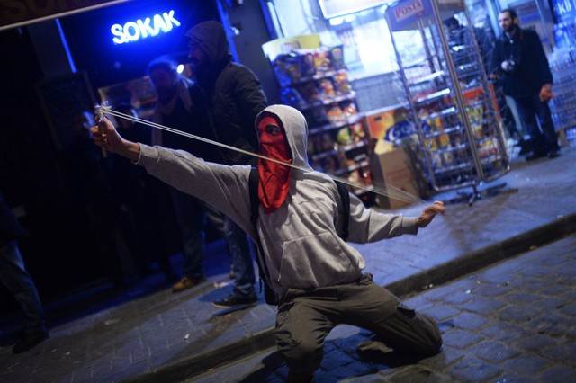 Một người biểu tình bắn súng cao su trong cuộc đụng độ với cảnh sát chống bạo động ở Istanbul, Thổ Nhĩ Kỳ.