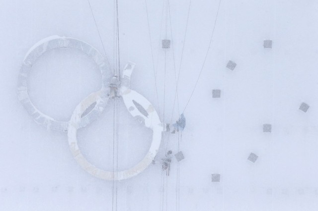 Công nhân làm việc trên vòng Olympic dưới mưa tuyết ở Krasnaya Polyana, Nga.