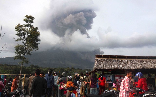 Mọi người nhìn tro bụi phun trào từ núi lửa Sinabung ở Karo, North Sumatra, Indonesia.