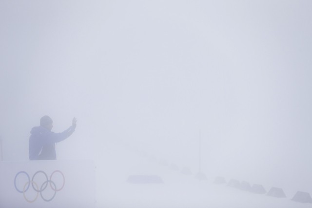 Một nhân viên phục vụ giơ tay chào trong màn sương dày tại một địa điểm thi đấu của Olympics mùa đông ở Sochi, Nga.