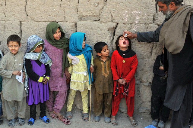 Một nhân viên y tế cho trẻ em uống vắc-xin phòng bại liệt ở ngoại ô Jalalabad, Afghanistan.