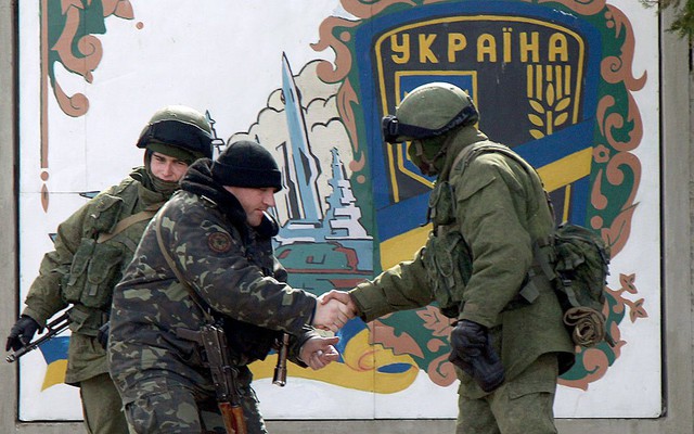 Một binh sĩ Ukraine (trái) bắt tay với một binh sĩ được cho là thuộc quân đội Nga tại căn cứ quân sự của Ukraine ở Perevalnoye.
