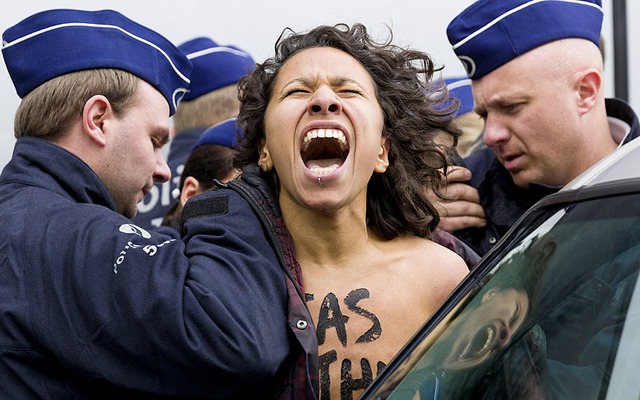 Cảnh sát bắt giữ một người biểu tình chống Nga thuộc nhóm Femen bên ngoài cuộc họp khẩn cấp của các Ngoại trưởng Liên minh châu Âu ở Brussels, Bỉ.