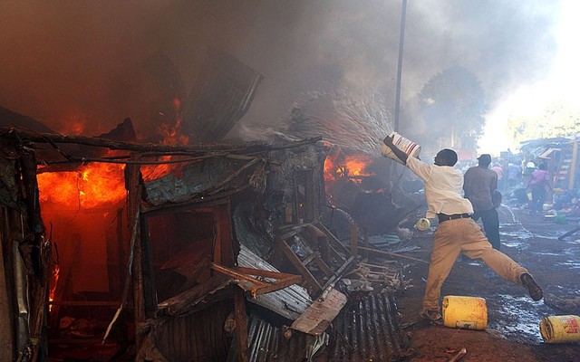 Người dân cố gắng chữa cháy sau khi hỏa hoạn xảy ra do chập điện tại khu ổ chuột Deep Sea ở Nairobi.