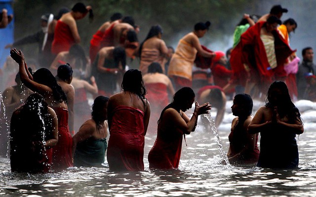 Phụ nữ theo đạo Hindu tắm trên sông Salinadi trong ngày đầu tiên của tháng lễ hội Madhav Narayan ở Sankhu, Nepal.