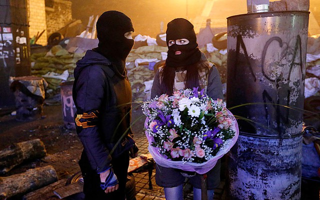 Một người biểu tình chống chính phủ tặng hoa bạn gái gần khu vực đụng độ với cảnh sát ở Kiev, Ukraine.