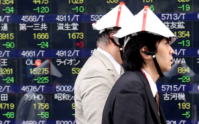 Các thương gia Nhật Bản đeo mũ bảo vệ đặc biệt trong khi tham gia cuộc diễn tập chống thảm họa ở Tokyo.