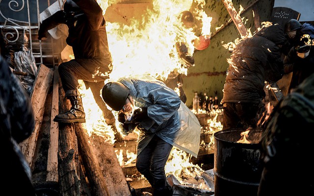 Người biểu tình bị bắt lửa sau hàng rào trong cuộc đụng độ với cảnh sát chống bạo động ở Kiev, Ukraine.
