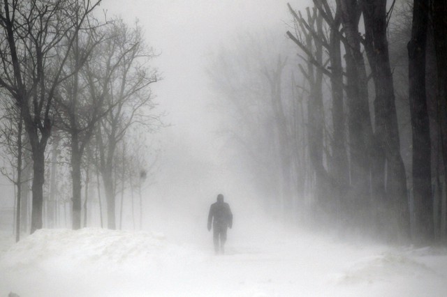 Người đàn ông đi trên đường phủ đầy tuyết trắng ở Bucharest, Romania.
