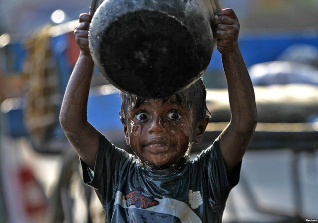 Một cậu bé tắm trên vỉa hè tại thành phố Chennai, Ấn Độ.
