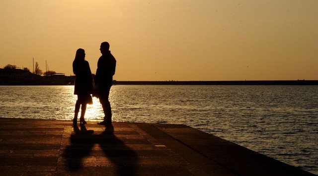 Một cặp đôi ngắm hoàng hôn trêm mặt biển tại bến cảng ở thành phố Sevastopol, Crimea.