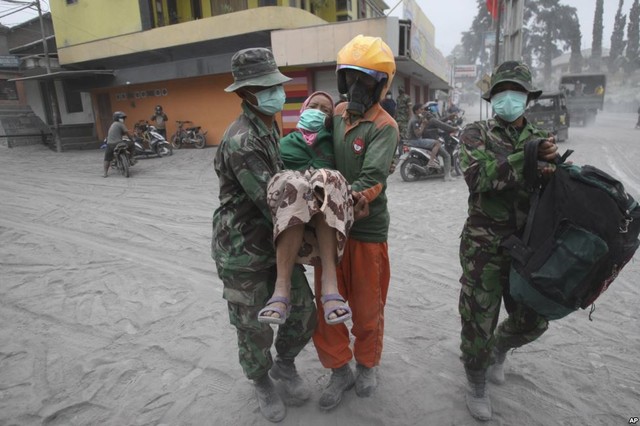 Các binh sĩ và nhân viên cứu hộ đưa một phụ nữ lên xe tải để đi sơ tán sau khi núi lửa Kelud hoạt động trở lại tại Malang, Đông Java, Indonesia.