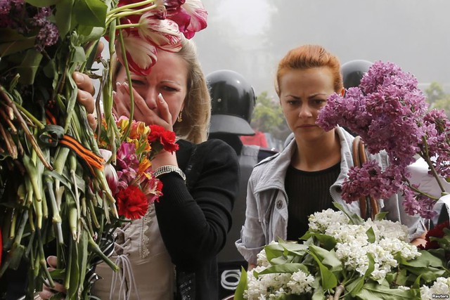Người dân đặt hoa viếng những người thiệt mạng bên ngoài tòa nhà nơi xảy ra vụ đụng độ đẫm máu hôm qua ở thành phố Odessa, Ukraine, khiến ít nhất 42 người thiệt mạng.