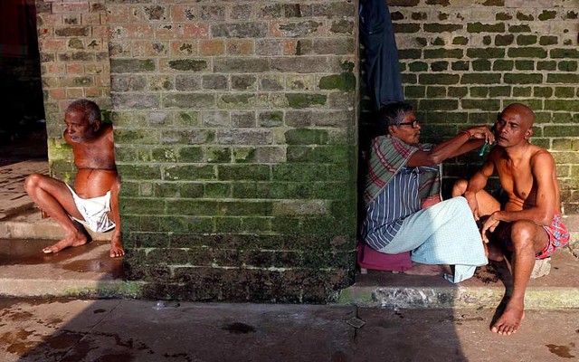 Một người theo đạo Hindu được cạo râu trước khi tham gia nghi lễ cầu nguyện trên bờ sông Hằng ở Kolkata, Ấn Độ.