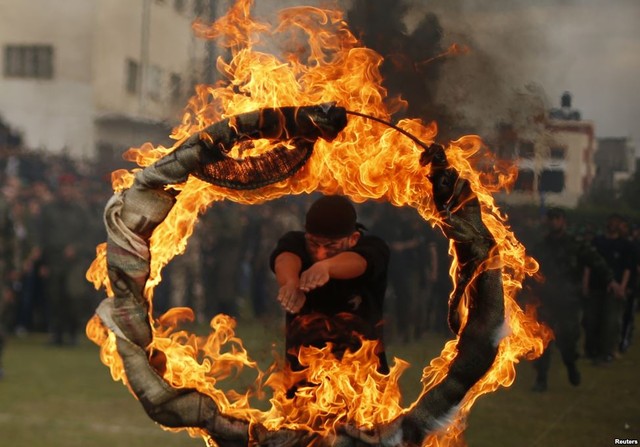 Một sinh viên người Palestine nhảy qua vòng lửa trong lễ tốt nghiệp một chương trình huấn luyện quân sự ở Dải Gaza.