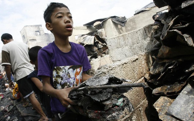 Mọi người tìm kiếm những đồ còn dùng được sau khi hỏa hoạn bùng phát tại một khu ổ chuột ở Manila, Philippines.