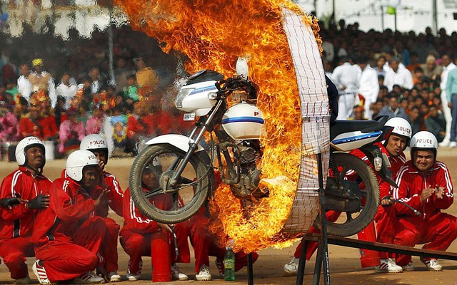 Một thành viên của đội cảnh sát Gujarat trình diễn màn đi xe máy qua vòng lửa trong lễ kỷ niệm quốc khánh Ấn Độ ở Himmatnagar.