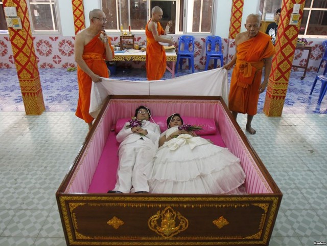 Chú rể Tanapatpurin Samangnitit và cô dâu Sunantaluk Kongkoon nằm trong quan tài trong nghi lễ đám cưới được tổ chức tại ngôi chùa Wat Takien, ngoại ô Bangkok, Thái Lan.