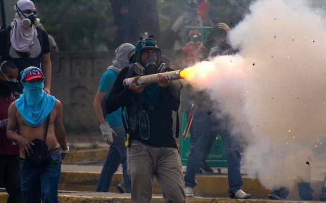 Người biểu tình đụng độ với cảnh sát chống bạo động ở thủ đô Caracas, Venezuela.