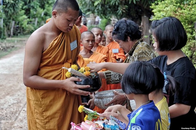 Một nhóm nhà sư đi khất thực qua một ngôi làng ở nông thôn Thái Lan.