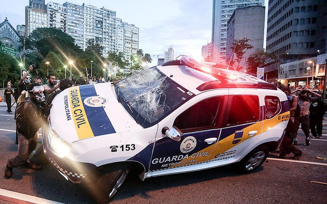 Người biểu tình đập phá và lật nghiêng xe của cánh sát trên đường phố Consolacao ở Sao Paulo, Brazil.
