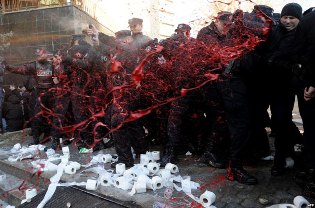 Mọi người té sơn đỏ vào cảnh sát Kosovo, Serbia, trong khi tập trung biểu tình yêu cầu hiệu trưởng trường đại học Pristina  từ chức.