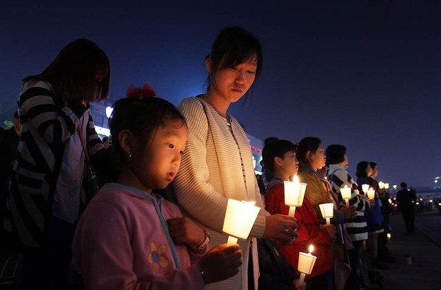 Học sinh và người dân thắp nến cầu nguyện cho các hành khách mất tích trở về từ phà Sewol bị chìm ngoài khơi bờ biển tây nam Hàn Quốc.