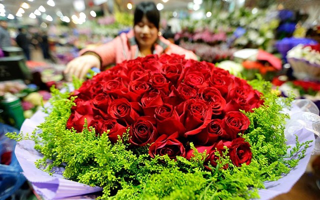 Một người bán hoa gói 99 bông hồng chuẩn bị cho ngày lễ Tình nhân ở Bắc Kinh, Trung Quốc.
