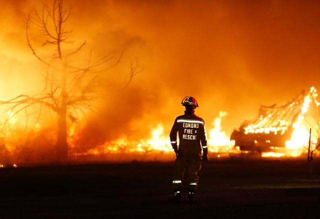 Lính cứu hỏa bất lực nhìn cháy rừng thiêu rụi một ngôi nhà di động ở Oklahoma, Mỹ.