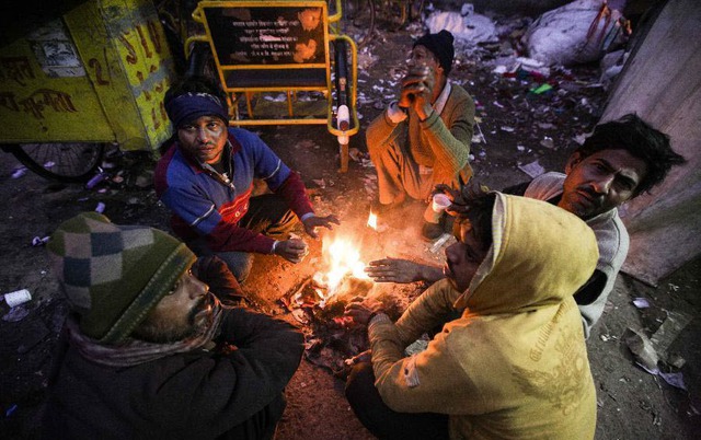 Những người lái xe kéo sưởi ấm quanh đống lửa khi nhiệt xuống thấp kỷ lục ở Old Delhi, Ấn Độ.