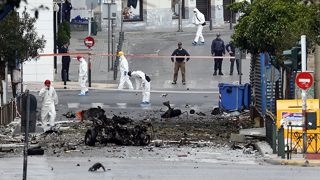 Các nhân viên điều tra tìm bằng chứng tại hiện trường vụ đánh bom xe ô tô trên đường phố ở Athens, Hi Lạp.