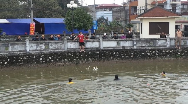 Dù trời rất lạnh nhưng rất nhiều thanh niên vẫn sẵn sàng ngâm mình dưới nước để tham dự lễ hội... bắt vịt của làng