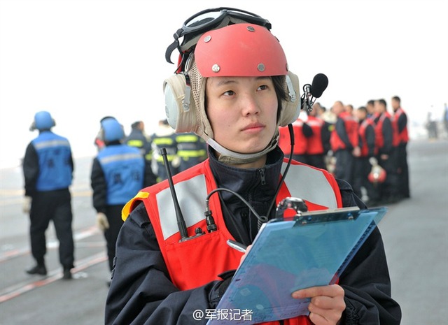 Hình ảnh một nữ nhân viên trong trang phục đỏ được giao nhiệm vụ tiếp tế vũ khí, đạn dược, bom.