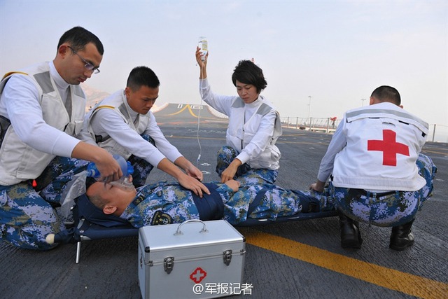 Nữ nhân viên y tế trong trang phục màu trắng có nhiệm vụ bảo đảm sức khỏe cho các quân nhân có mặt trên tàu sân bay.