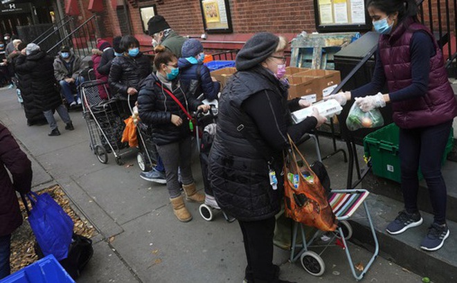 Dòng người xếp hàng chờ nhận thực phẩm cứu trợ tại khu Manhattan ở TP New York hôm 11-12. Ảnh: Reuters