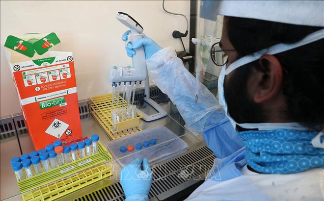 Kỹ thuật viên phân tích mẫu bệnh phẩm COVID-19 tại phòng thí nghiệm ở Glasgow, Anh ngày 22/4/2020. Ảnh: AFP/TTXVN