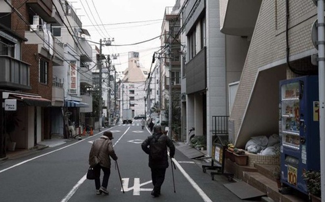 Những người cao tuổi đi bộ dọc con phố ở quận Toshima, thủ đô Tokyo. Ảnh: Bloomberg