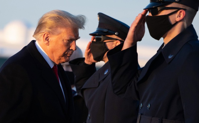 Tổng thống Mỹ Donald Trump (trái) chuẩn bị đáp chuyên cơ Air Force One ở căn cứ không quân ở Maryland tới Mar-a-lago ngày 23/12/2020. Ảnh: AFP/TTXVN