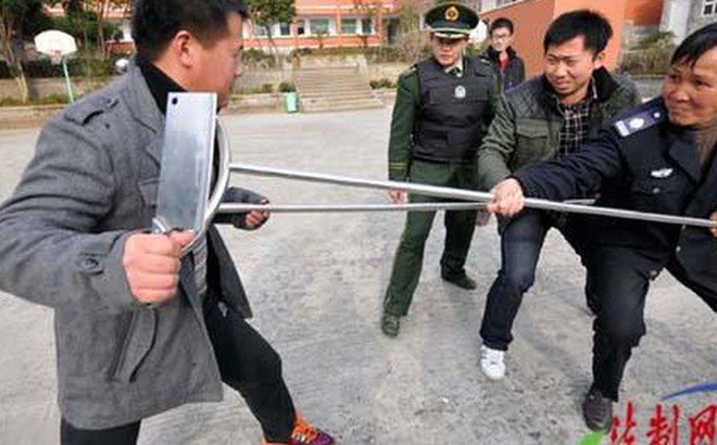 Cảnh sát Trung Quốc hướng dẫn học sinh vô hiệu hóa nghi phạm tiềm tàng trong một vụ tấn công bằng dao. Ảnh: Weibo